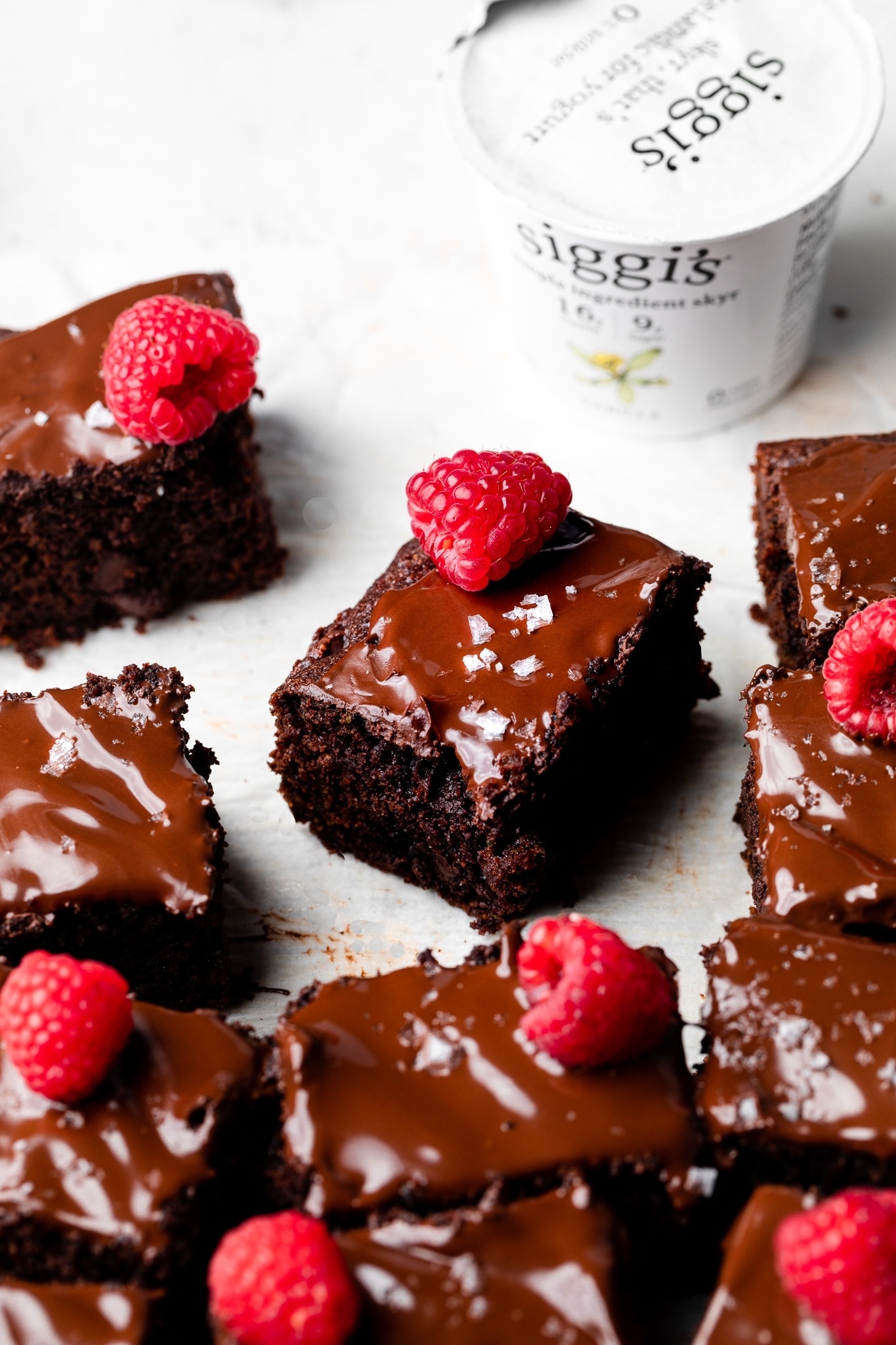 gluten free chocolate zucchini cake slices next to a container of yogurt