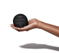 hand holding a container of lotion